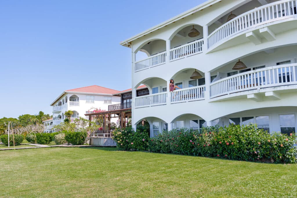 A guest sitting on the railing of a balcony of the second floor unit at Umaya Resort